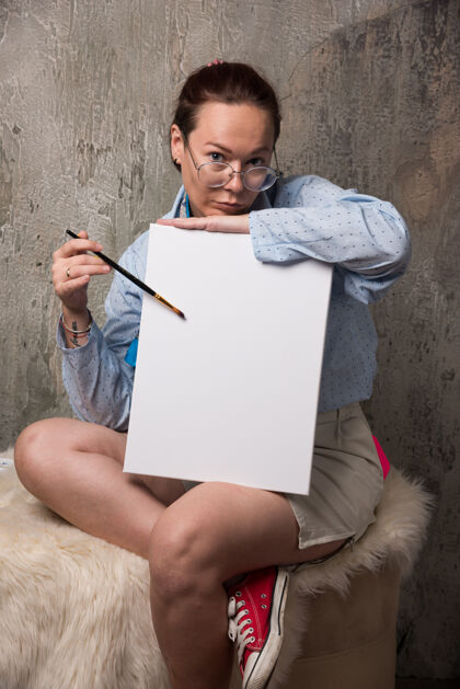 女士坐在大理石上用帆布和画笔画画的女人高质量的照片画布女性眼镜
