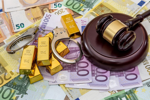 银行在欧元钞票上戴着法官的木槌和手铐的金条金融现金罪犯