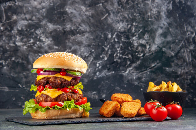 午餐特写镜头美味的三明治和鸡块番茄酱在黑色托盘番茄在深色表面三明治健康番茄酱