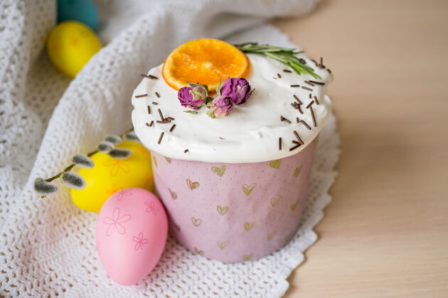 传统木制桌子上装饰着橘子和鸡蛋的复活节蛋糕复活节快乐沙拉三明治蔬菜