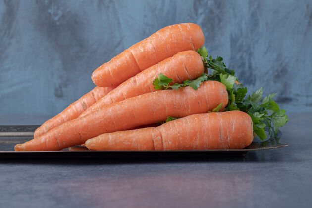 堆一堆胡萝卜在托盘上 在大理石表面上蔬菜好吃庄稼