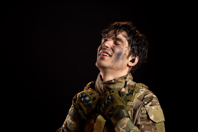 肖像一个穿着制服的年轻士兵在黑暗的墙上的画像成人人制服