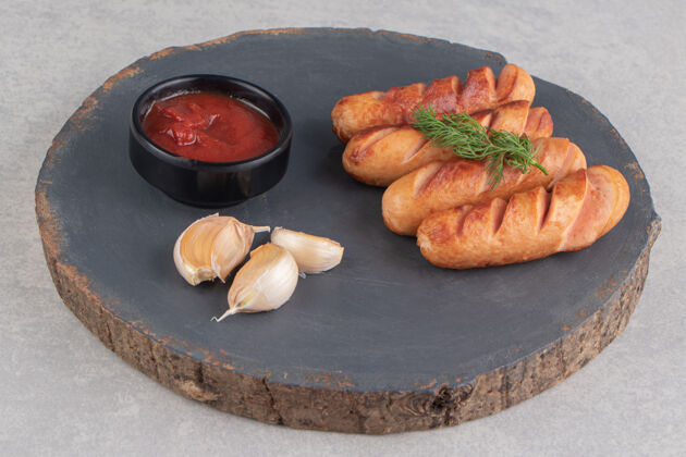 烤美味的油炸香肠 大蒜和番茄酱放在木片上薯条新鲜食物