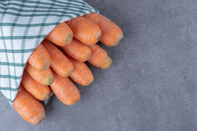 美味胡萝卜裹在毛巾里 放在大理石表面营养新鲜生的