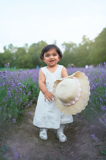 农场微笑的女婴在薰衣草草地上摆姿势宝贝可爱小