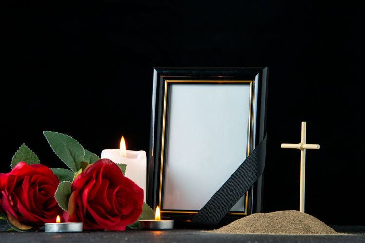 空白黑暗中 鲜花和蜡烛点缀着小坟墓的正视图葬礼玫瑰花