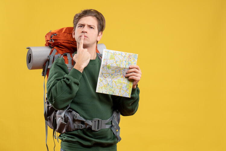 黄色正面图年轻男子背着背包拿着地图旅行自然家伙