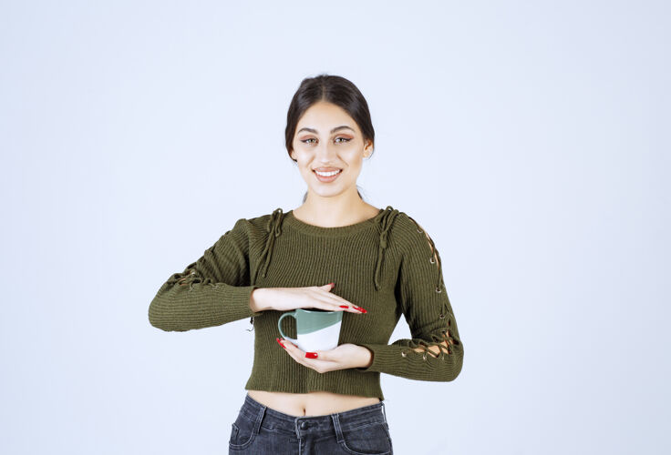 热的一个年轻漂亮的女模特拿着杯子看着镜头摆姿势女人人