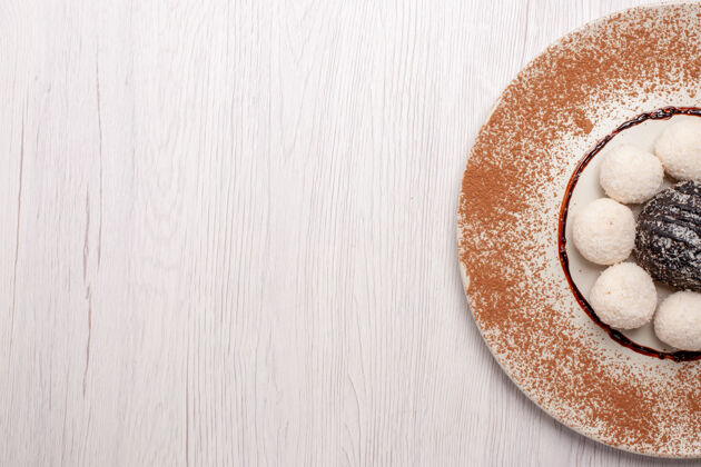 糖果俯瞰美味的椰子糖和巧克力蛋糕放在白色桌子上糖蛋糕饼干甜糖果饼干视图健康烘焙食品