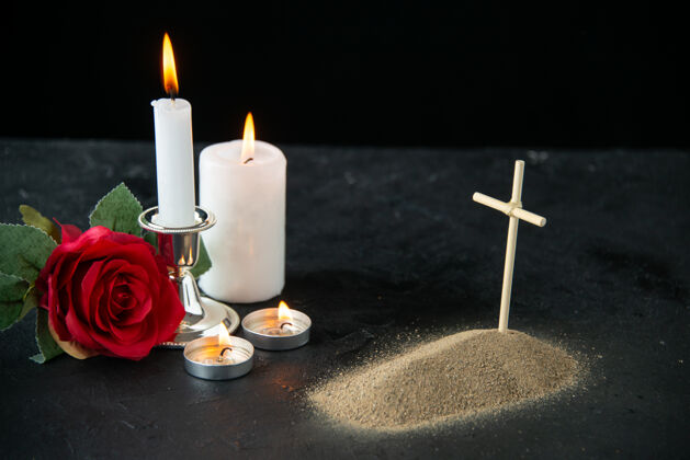 黑暗红色玫瑰和黑色蜡烛的小坟墓正面图红打蜡葬礼