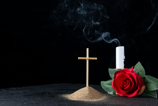 墓地黑色上有红花的小坟墓的正面图玫瑰葬礼光
