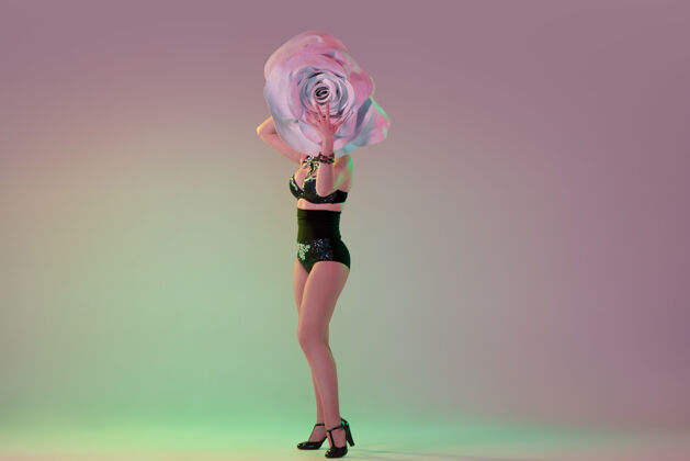 春天年轻的女舞者 戴着巨大的花帽 在霓虹灯下 斜墙上魅力设计移动