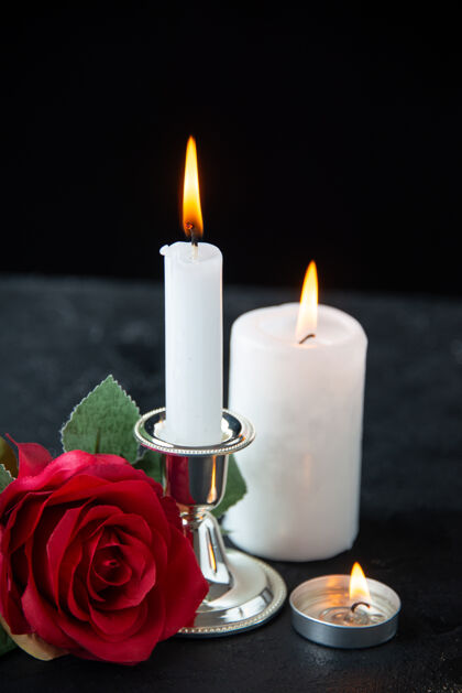 蜡烛红色玫瑰和黑色蜡烛的小坟墓的正面图死亡红葬礼
