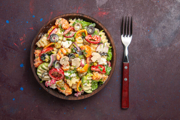 蘑菇俯瞰美味的蔬菜沙拉 番茄 橄榄和蘑菇 深色背景 健康沙拉 蔬菜午餐小吃炒锅顶部午餐