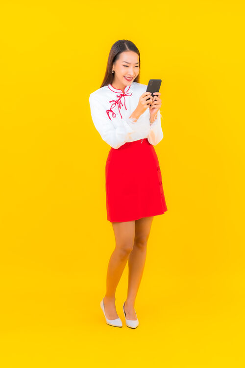 成人用黄色的智能手机描绘美丽的亚洲年轻女子通话聊天设备
