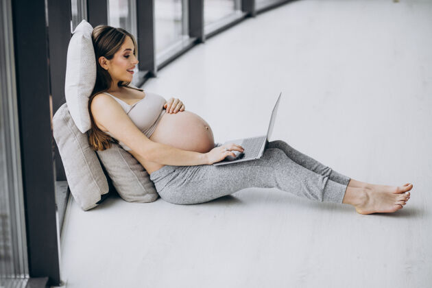 怀孕女人在家用电脑生活孕妇靠窗