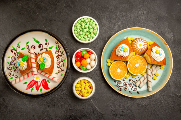 食品顶视图美味的馅饼片与橘子和糖果的深灰色背景水果糖果蛋糕馅饼面团茶盘子容器餐