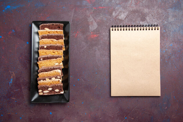小吃俯视图美味蛋糕片与坚果蛋糕锅内黑暗的背景甜茶蛋糕糖饼干饼干饼干茶顶部派