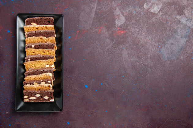 糖俯视图美味的切片蛋糕与坚果蛋糕平底锅内深色背景甜可可蛋糕饼干馅饼糖饼干派蛋糕美味