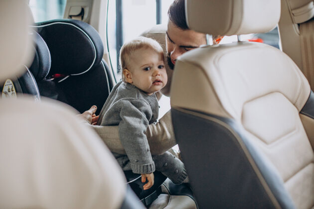 抱着爸爸带着小女儿在汽车展厅里汽车汽车座椅女婴