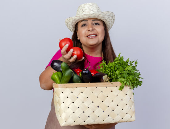 快乐围裙戴帽的中年园丁 手里拿着装满蔬菜的箱子 满脸笑容花园年龄中年