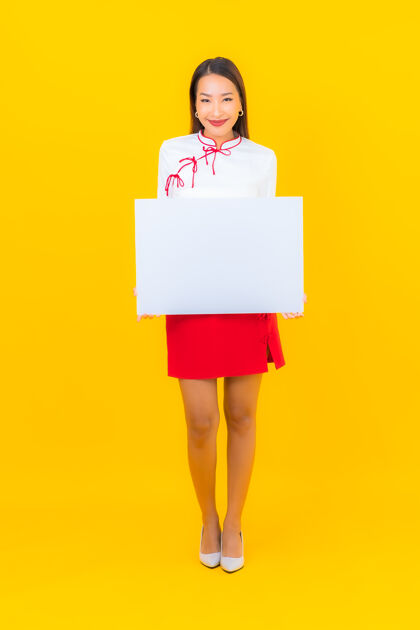 健康肖像美丽的亚洲年轻女子在黄色的广告牌上展示白色的空广告信息日语学生