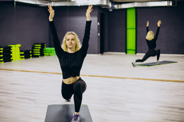 女性在健身房的垫子上练习瑜伽的女人肌肉努力普拉提