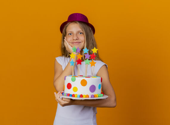 漂亮戴节日礼帽的漂亮小女孩拿着生日蛋糕笑脸 生日派对概念蛋糕派对节日