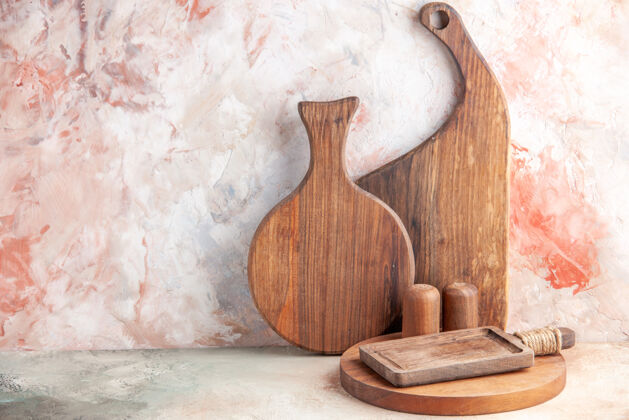烹饪各种木质砧板的正面图矗立在五颜六色的表面上支架传统勺子
