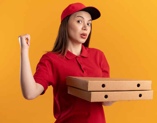 背一个穿着制服的漂亮送货员拿着披萨盒 把点拿回来披萨橘子拿着