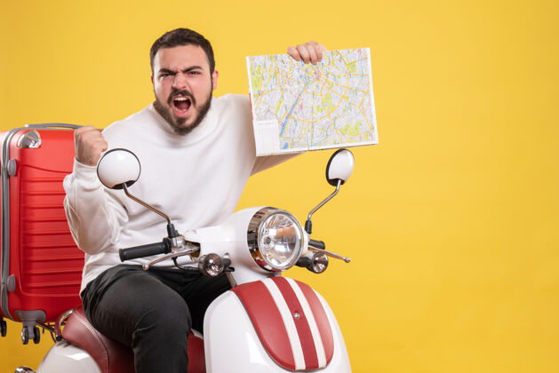 抱着顶视图愤怒的年轻人坐在摩托车上 手提箱上拿着地图 背景是孤立的黄色自行车微笑背景