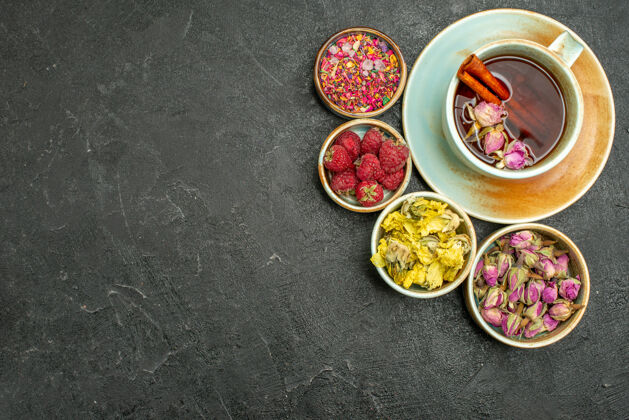 午餐顶视图一杯茶 以花和覆盆子为深色背景 茶果味饮花香晚餐风味覆盆子