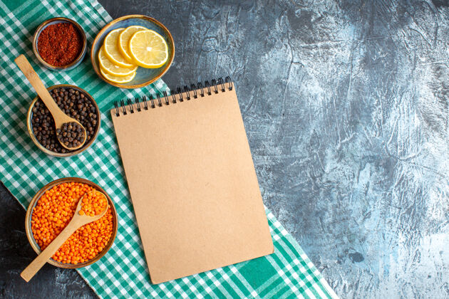 空晚餐背景俯视图 不同香料黄豌豆和黑色桌子上的螺旋笔记本不同的香料豌豆空白
