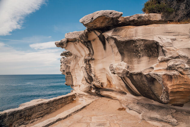 海岸美丽的拍摄一个岩石陡峭的悬崖附近的大海与蓝天海岸线悬崖夏天
