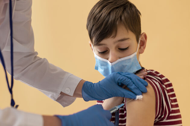 男孩特写镜头戴着面具的男孩在接种疫苗儿童科学健康