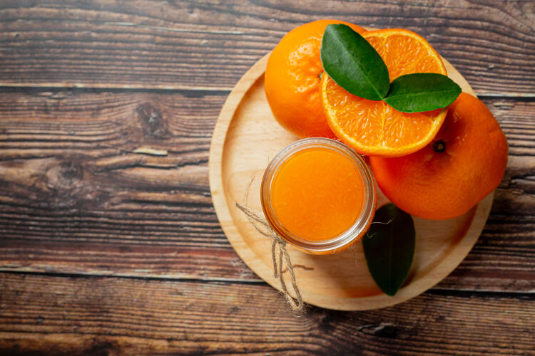 维生素c新鲜的橙汁在黑暗的木制背景玻璃果汁挤压橙子