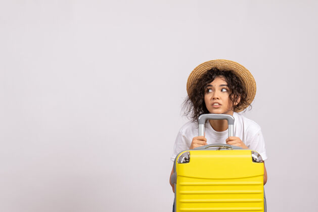 航行正面图年轻女性带着黄色的包准备在白色背景上旅行阳光颜色航行休息旅游飞行度假人年轻女性飞行