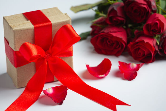 周年纪念大理石背景上的红玫瑰和礼品盒浪漫丝带礼物