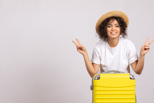 航行正面图年轻女性带着黄色包准备乘坐白色背景色的航班休息航程飞机旅游度假旅行飞行年轻女性