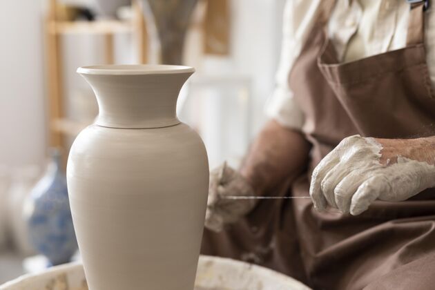 艺术家近距离的手和粘土一起工作陶器创作工匠
