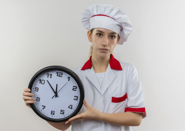 制服自信的年轻漂亮厨师穿着厨师制服 拿着白色墙上孤立的时钟烹饪自信年轻