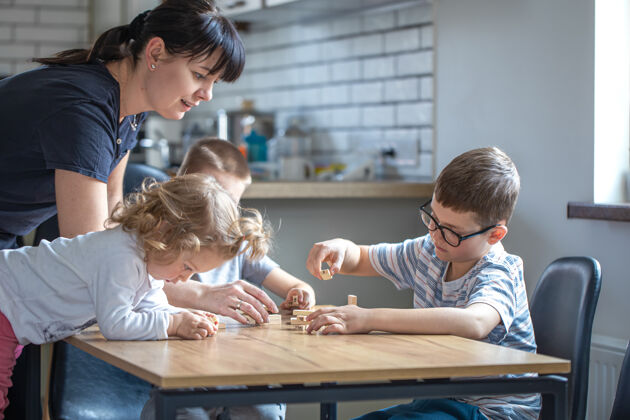 发展孩子们在家里和妈妈在厨房里玩木板游戏堆栈情感小