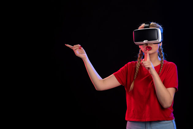 成人年轻女性在黑暗的墙上玩虚拟现实的前视图游戏正面一