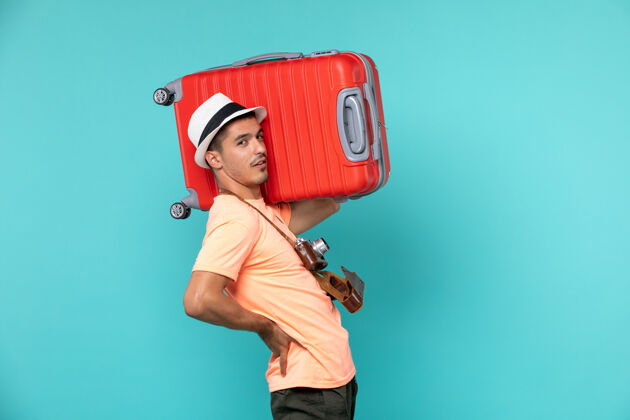 航行度假的男人拿着蓝色的大红色手提箱旅行大旅程