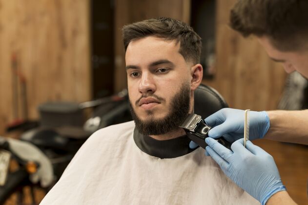 工作在理发店理胡子的年轻人就业修剪男人