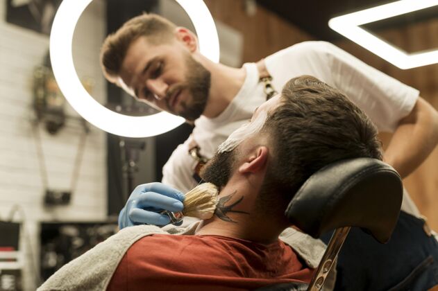 理发师理发师用剃须膏勾勒男顾客的胡须轮廓理发师职业横向