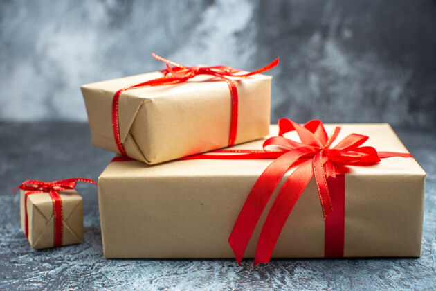 庆祝前视图圣诞节礼物与红色蝴蝶结结结上浅黑色新年照片节日彩色礼物圣诞节正面礼物盒子