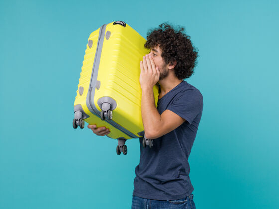 男性度假的男人手里拿着蓝色的黄包黄色成人航行