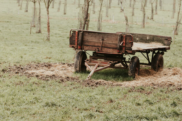 土地农田里挂在拖拉机上的农用车的视图草地设备机器