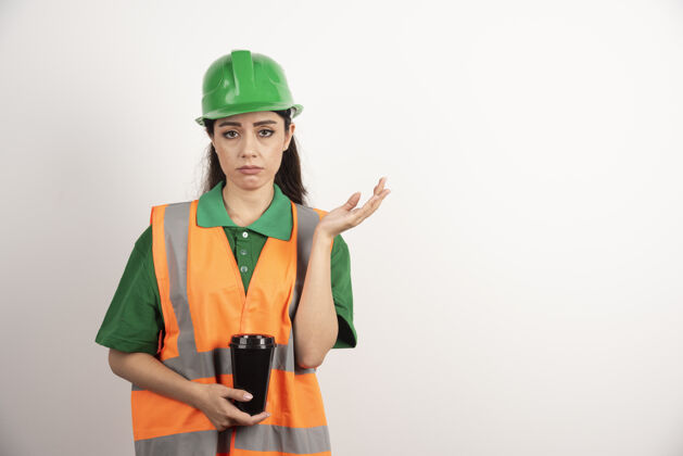 热年轻的女建造师拿着黑色的杯子高质量的照片年轻工作女